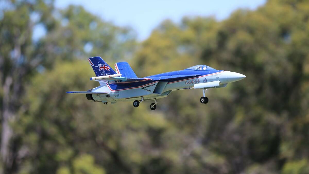 A remote-controlled F-18 prepares to land.